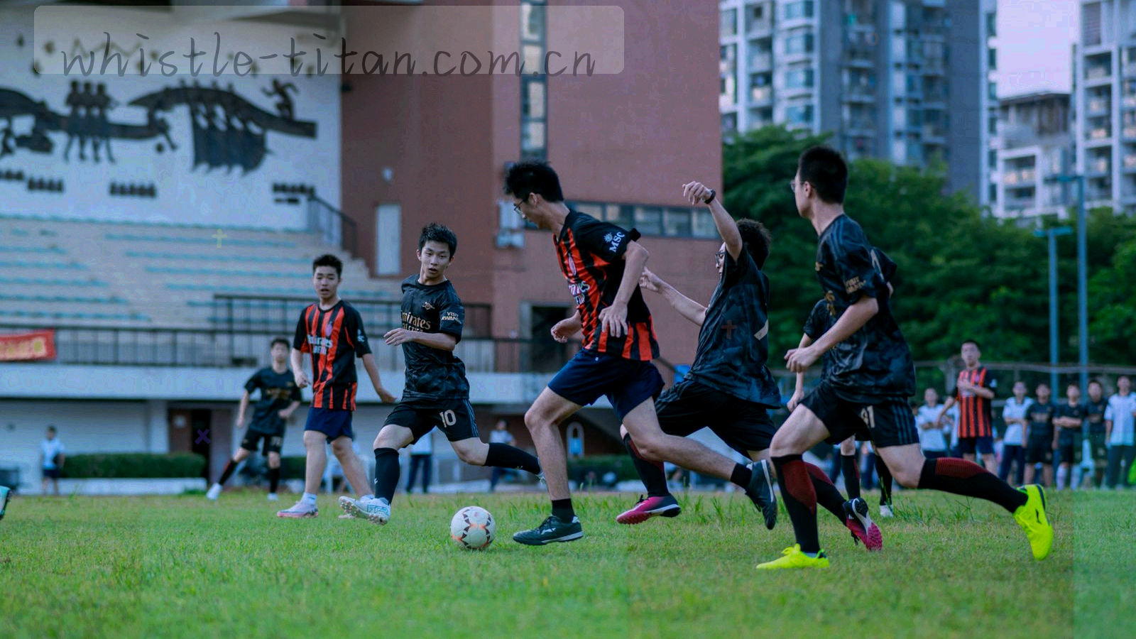 夜间赛场看台与计时显示牌的长焦压缩画面，冷银色灯光铺满看台层级